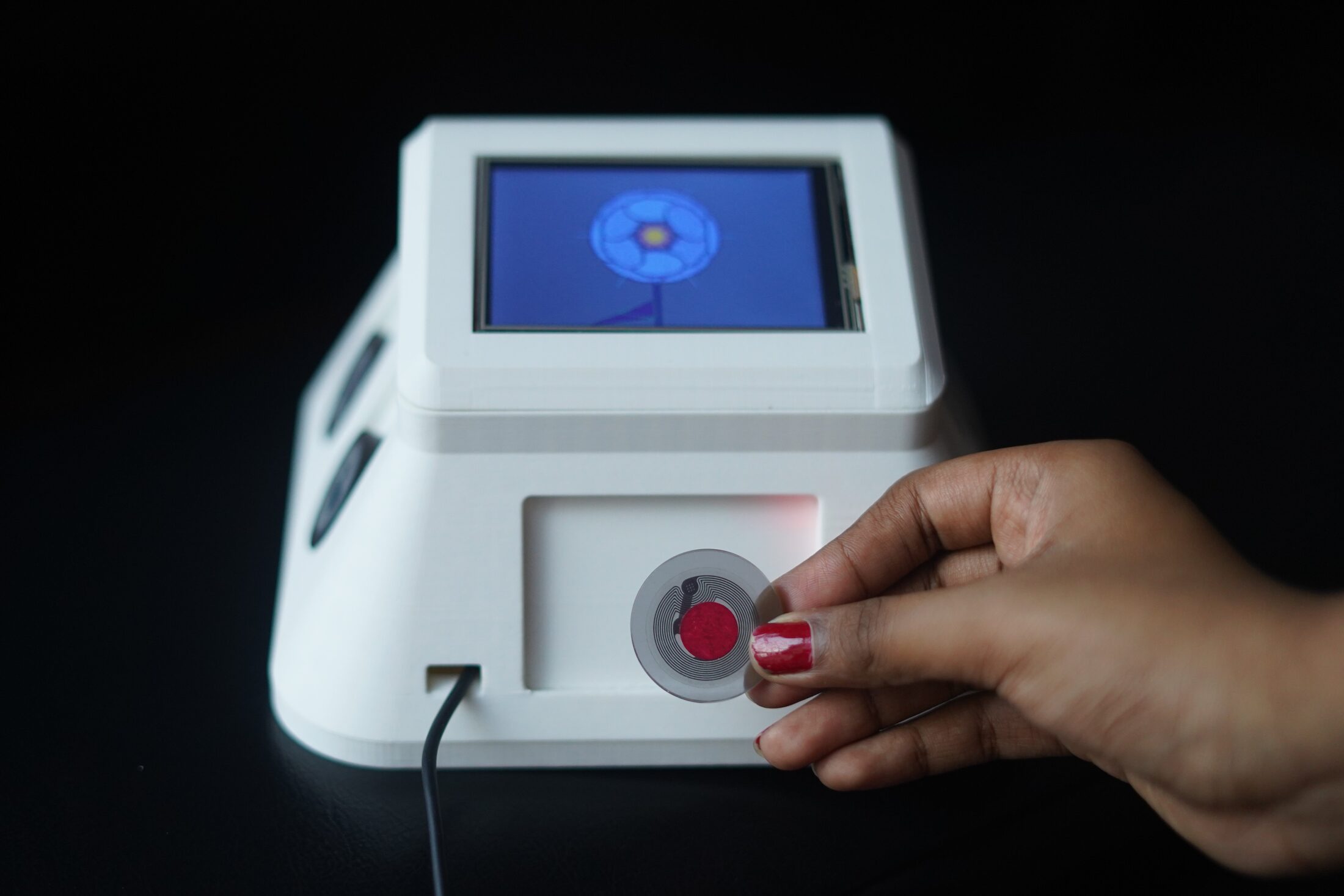 Hand tapping a red-dotted NFC token into the side slot of Teleflora