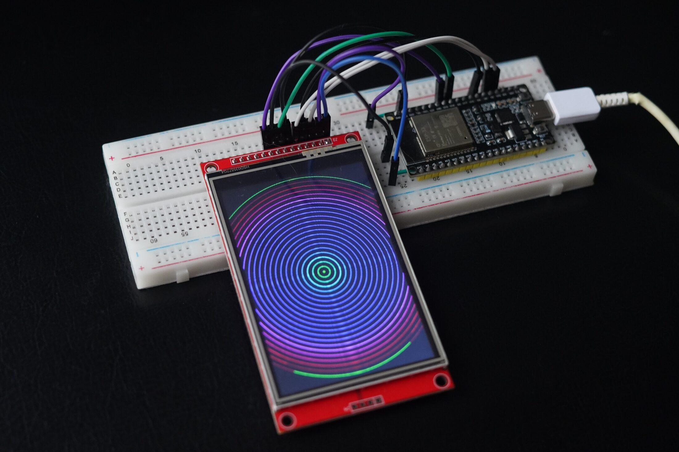 TFT display on breadboard rendering concentric circle pattern driven by ESP32