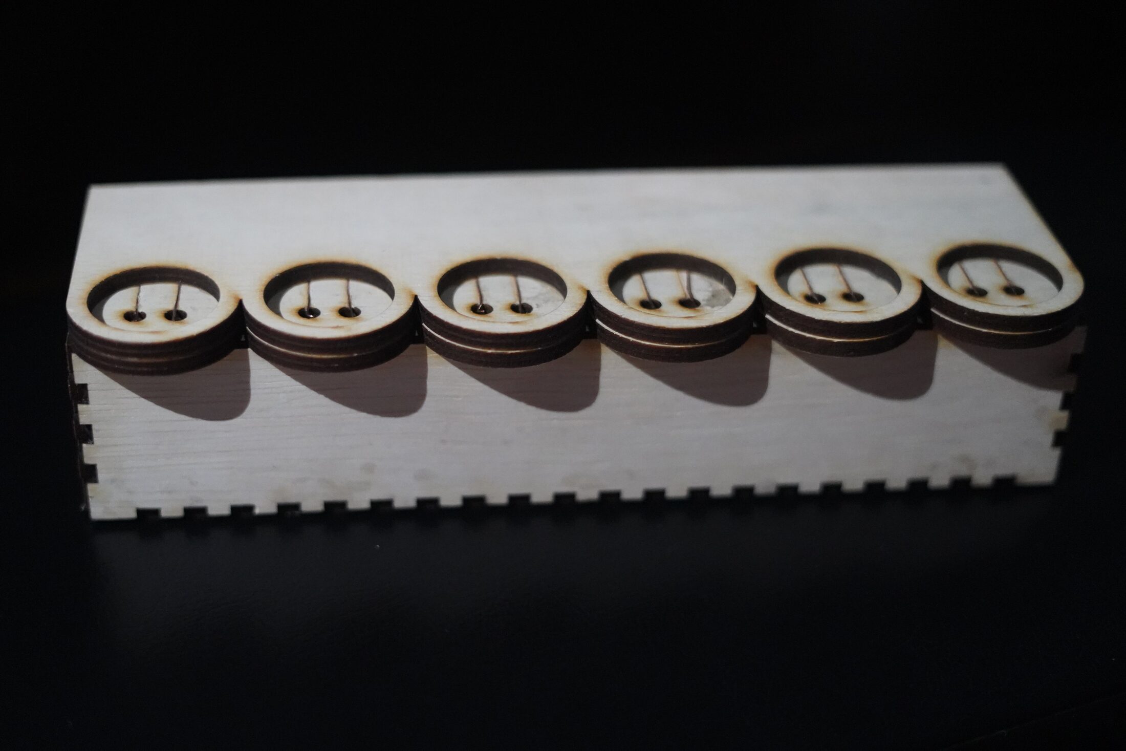 Wooden block with six coin-shaped resistor tokens on top